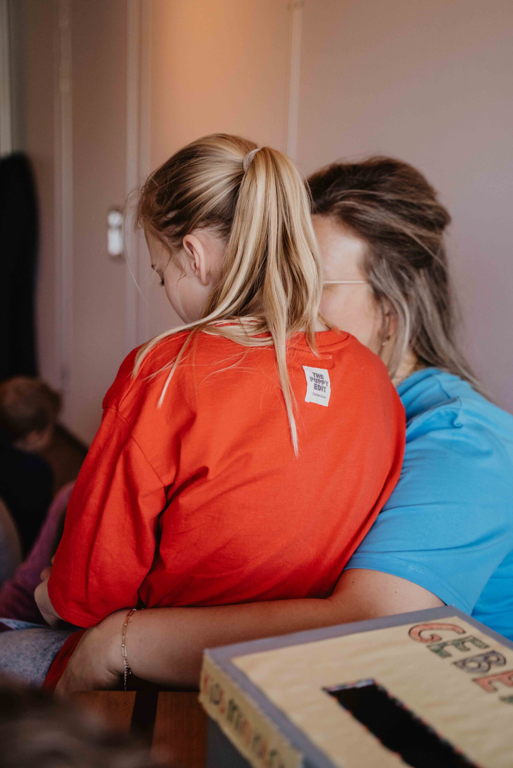 Twee meisjes omarmen elkaar tijdens een kidsbijeenkomst van Mozaiek033