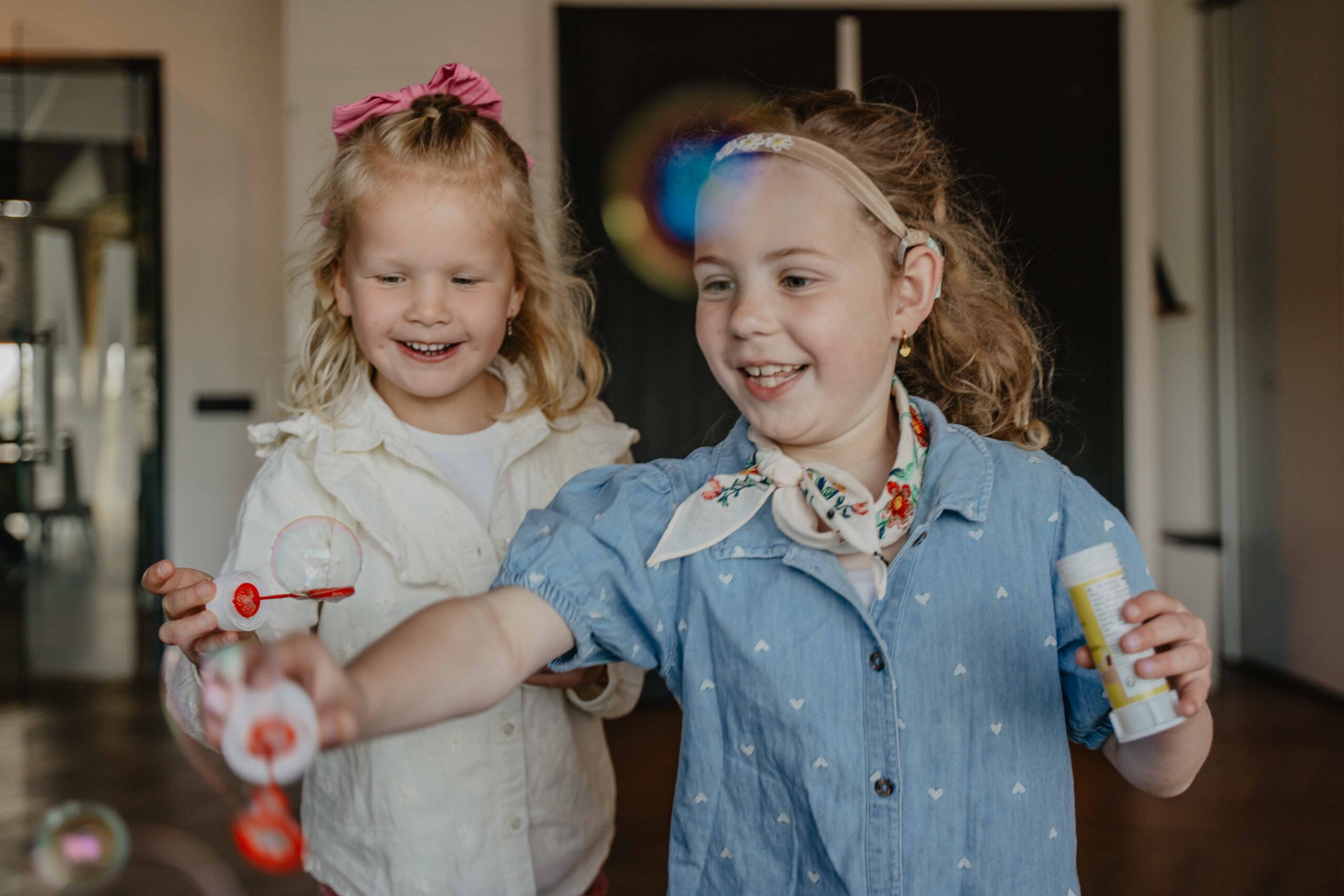 Twee lachende meisjes blazen bellen in de kidszaal