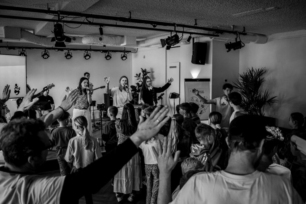 Kinderen zingen met opgeheven handen tijdens Kids Worship van Mozaiek033