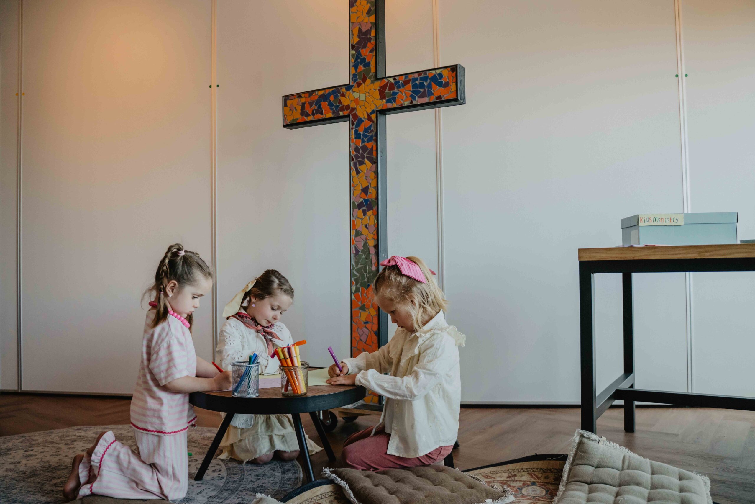 Drie jonge kinderen spelen samen aan een laag tafeltje in de kidszaal van Mozaiek033