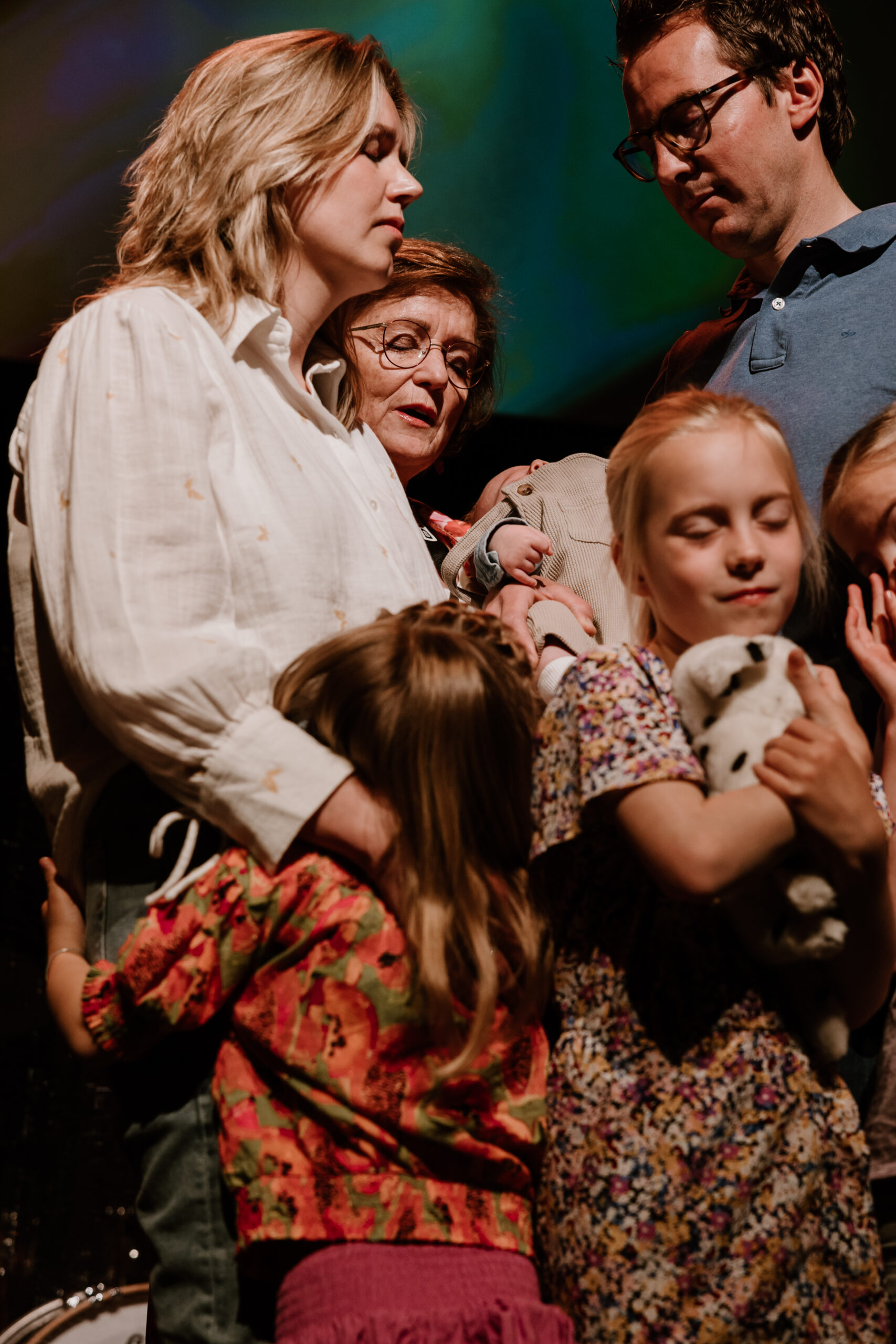 Gezin staat met hun baby op het podium tijdens een opdraagdienst