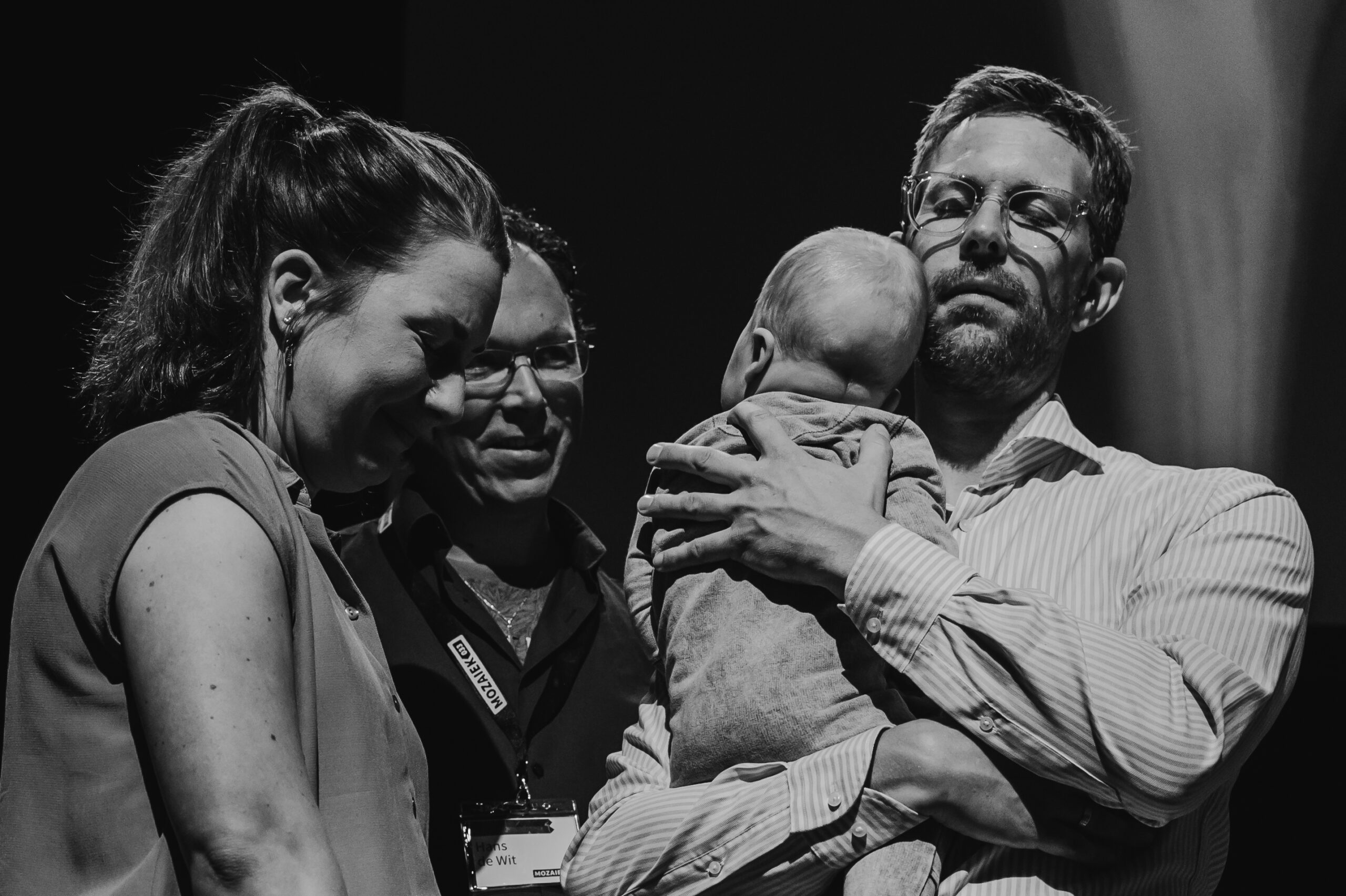 Ouders houden hun baby vast tijdens de opdraagdienst
